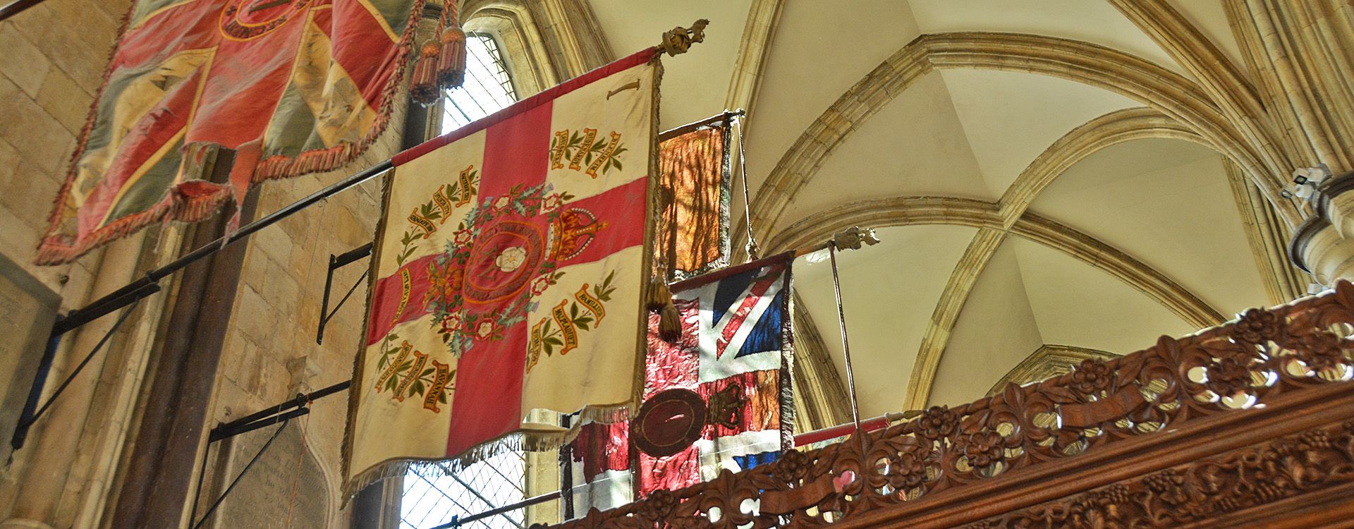 Regimental standards hang above chapels in Beverley Minster's South Transept.