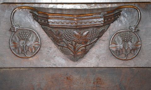 A close-up of a carved wooden 'misericord' showing floral details.